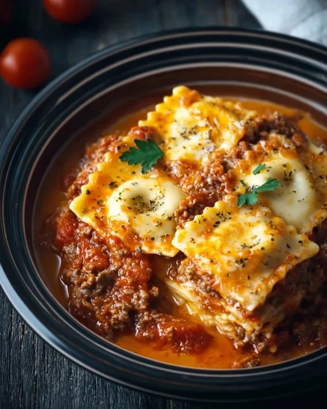 Bowl of delicious Crockpot Ravioli Lasagna with layers of cheese and sauce.
