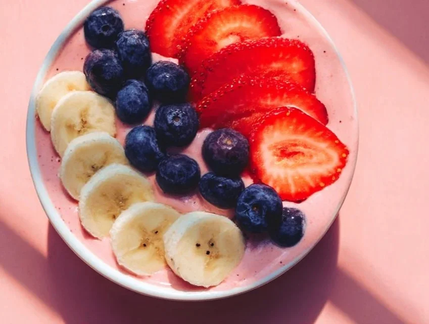 Colorful fruit smoothie bowl topped with fresh berries and granola.