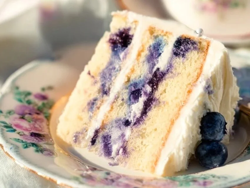 Lemon blueberry cake topped with fresh blueberries and lemon zest